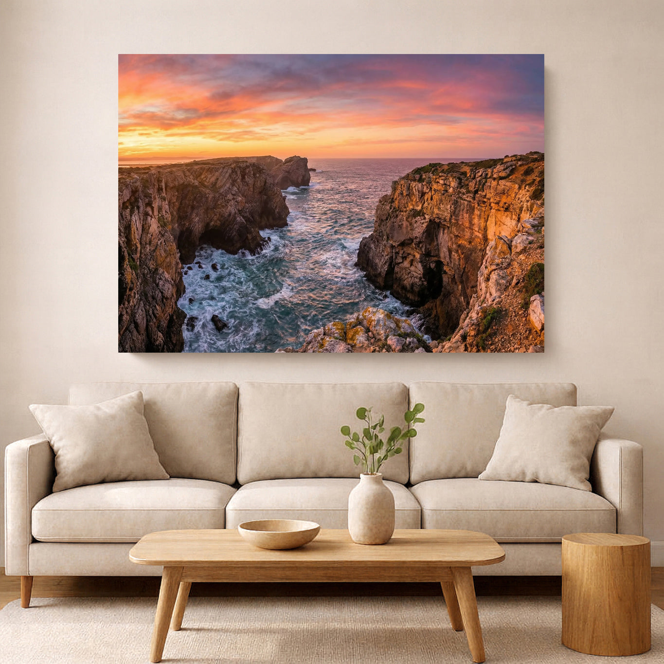 Living room with a large wall art of a sunset over cliffs, beige sofa, wooden coffee table, and decorative items.