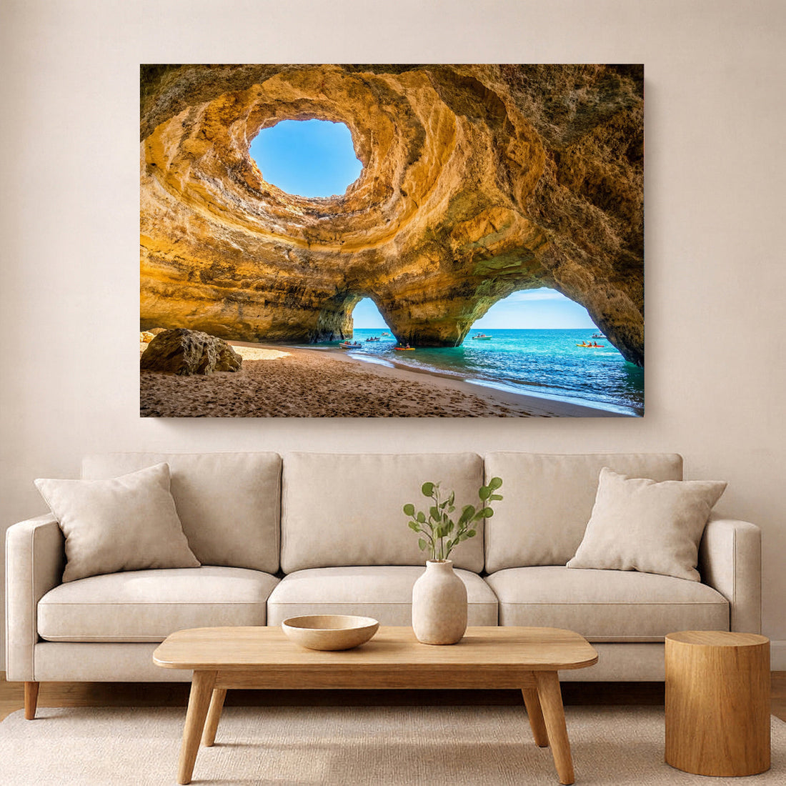 Large framed canvas print of the Algarve coastline displayed above a white sofa in a bright modern living room — Portugal Canvas Co.