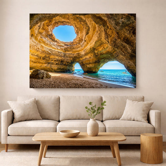 Large framed canvas print of the Algarve coastline displayed above a white sofa in a bright modern living room — Portugal Canvas Co.
