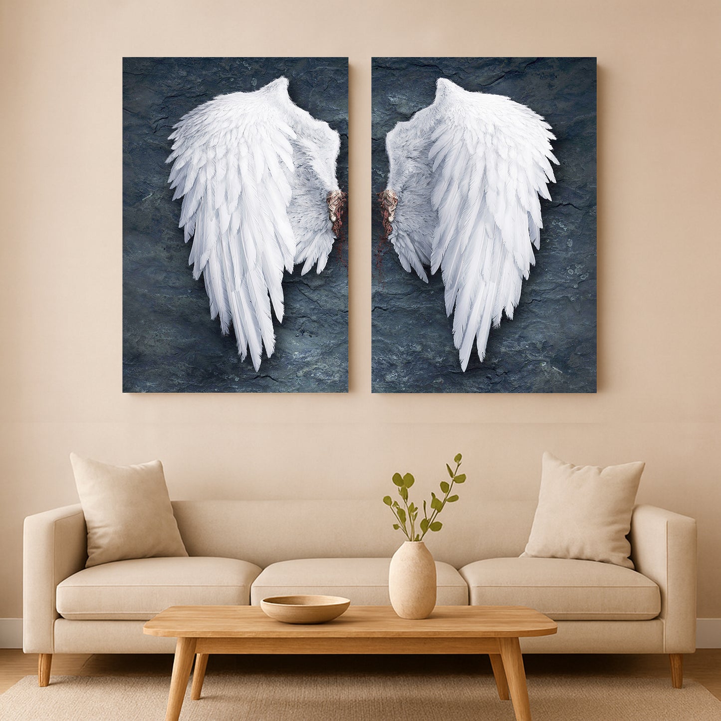 Two large wall art pieces of Banksy style angel wings hanging above a beige sofa in a living room.