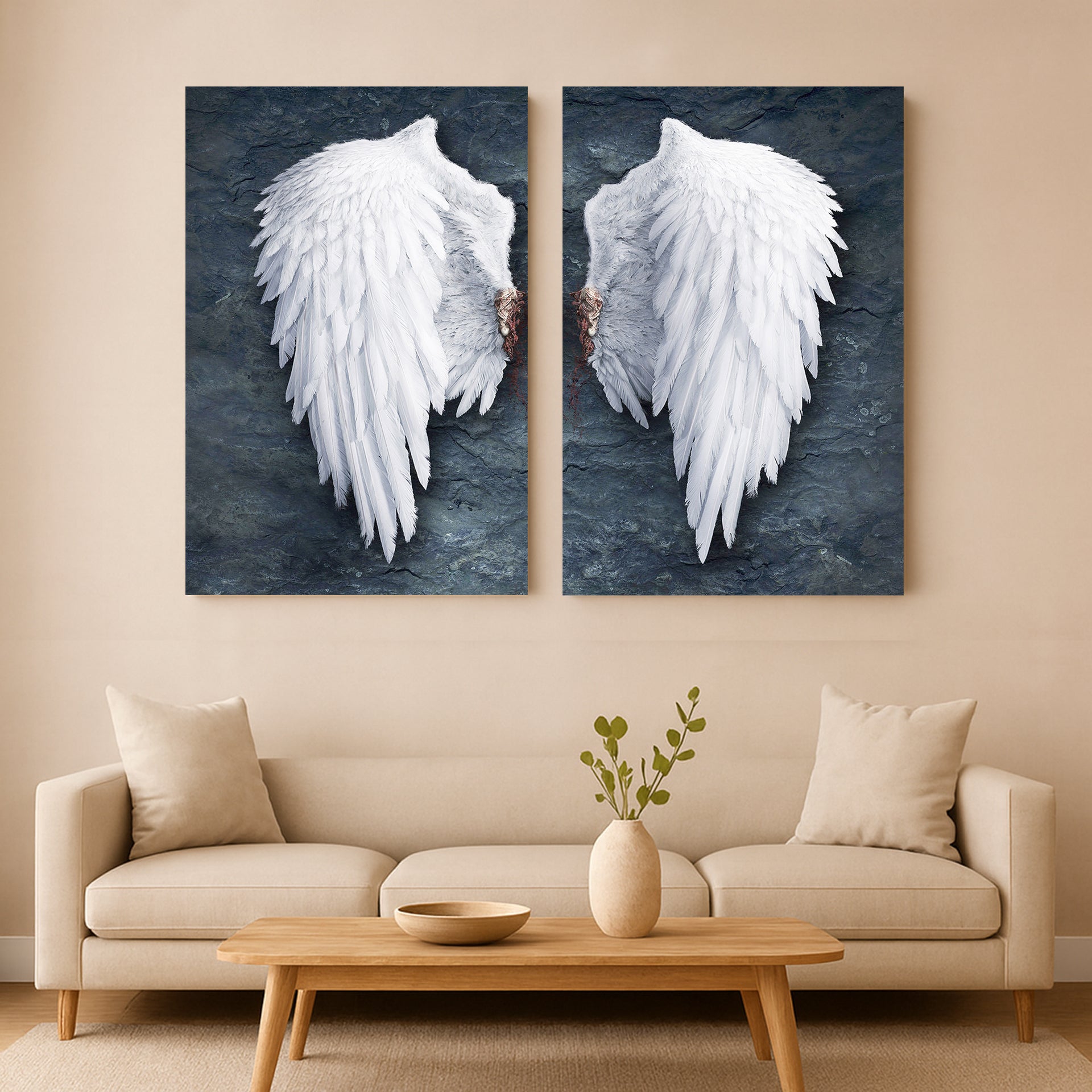 Two large wall art pieces of Banksy style angel wings hanging above a beige sofa in a living room.