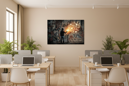 Be the Light in the Darkness Banksy-style graffiti canvas wall art displayed in a modern open plan office with plants and neutral tones - Portugal Canvas Co

