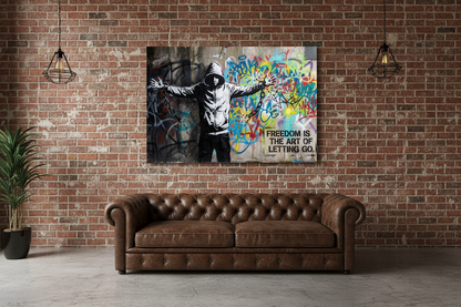 Freedom Is the Art of Letting Go Banksy-style graffiti canvas wall art with hooded figure breaking chains displayed in a cool urban loft apartment - Portugal Canvas Co

