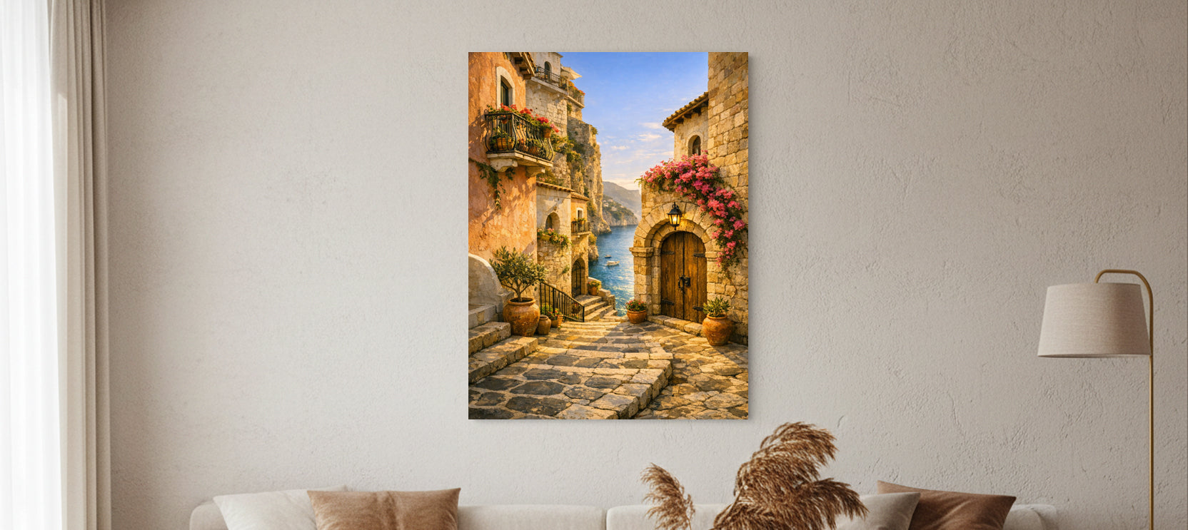 Large framed Mediterranean alleyway artwork hanging above a white sofa in a cozy living room with beige walls, warm cushions, and a gold floor lamp.”