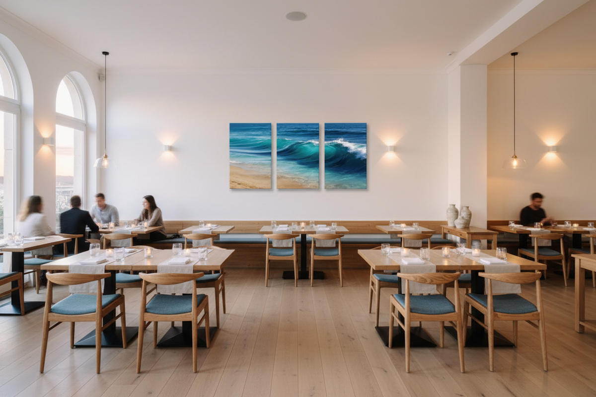 Ocean wave triptych canvas wall art displayed in an upscale coastal restaurant with white walls and wooden tables - Portugal Canvas Co