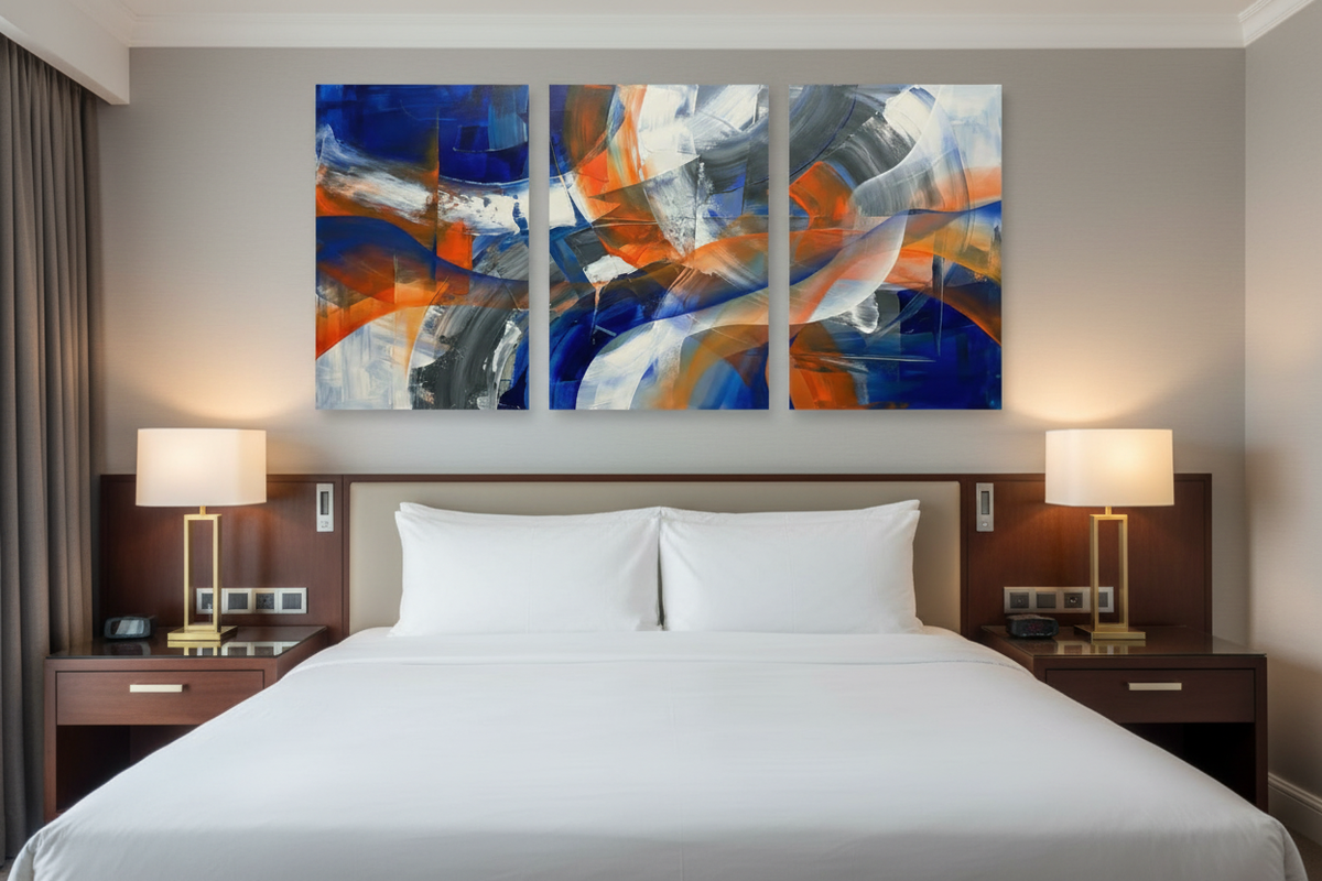 Blue and orange abstract brushstroke triptych canvas print displayed above a luxury hotel bed - Portugal Canvas Co