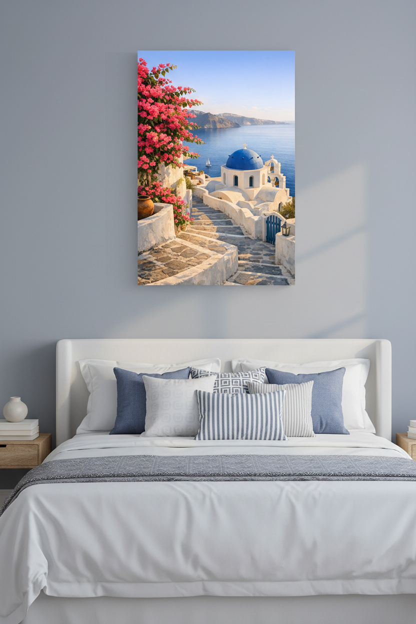 Santorini blue dome church canvas wall art with pink bougainvillea hung on a soft blue-grey wall above a white bed with coastal cushions in an elegant bedroom - Portugal Canvas Co