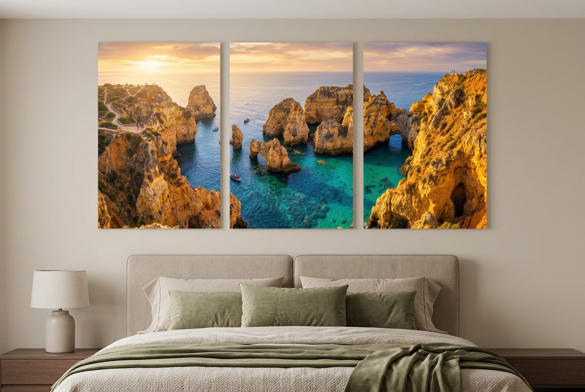 Golden coastal cliffs and turquoise sea sunset canvas triptych displayed above a bed in a neutral bedroom - Portugal Canvas Co