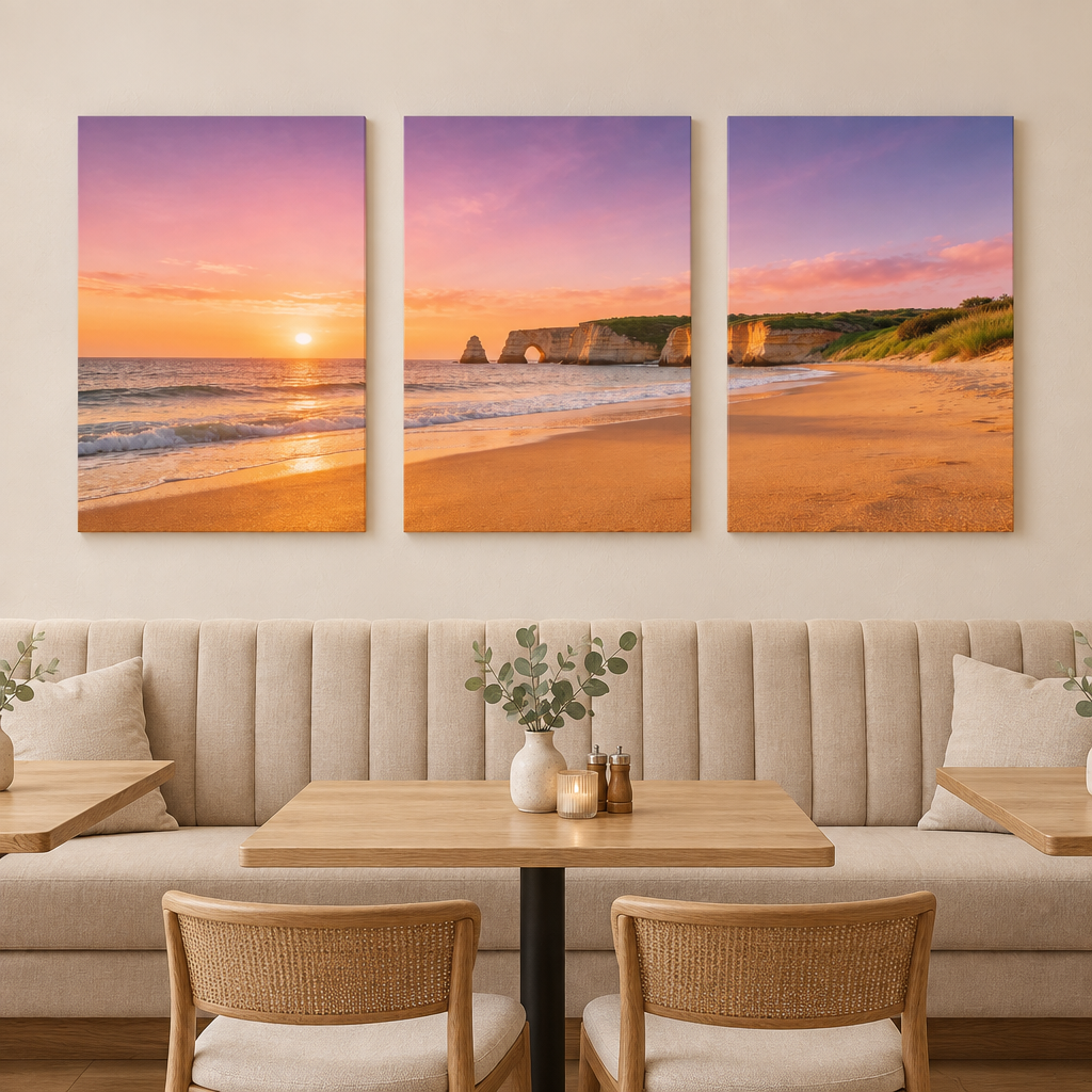 Three-panel Algarve cliff arch and beach sunset canvas set above a restaurant lounge banquette - Portugal Canvas Co