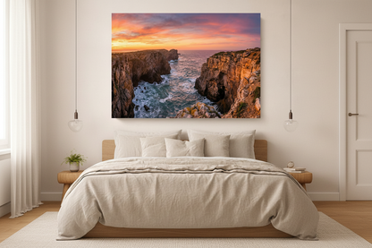 Portuguese coastal cliffs dramatic rock arch sunset canvas wall art displayed above a bed in a bright minimalist bedroom - Portugal Canvas Co