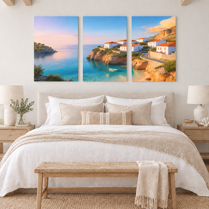 Three coastal village canvas panels above a cream bed in a softly lit coastal bedroom - Portugal Canvas Co