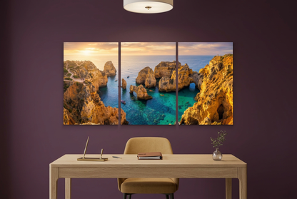 Three-panel golden coastal sunset canvas with turquoise water in a plum-coloured home study - Portugal Canvas Co