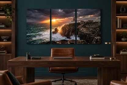 Lighthouse storm sunset three-panel canvas above a walnut desk in a teal study - Portugal Canvas Co