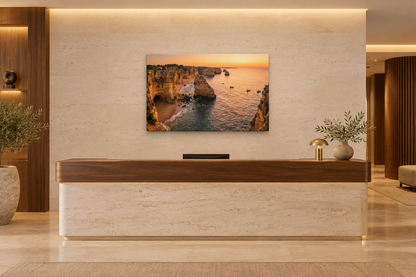 Algarve cliffs sunset canvas above a walnut reception desk in a boutique hotel lobby - Portugal Canvas Co