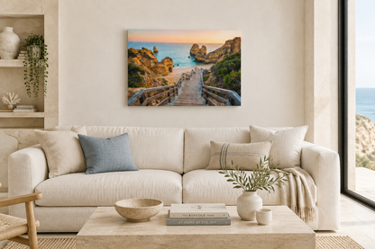 Algarve beach staircase canvas with cliffs and sea at sunset above an ivory sofa in a coastal living room - Portugal Canvas Co