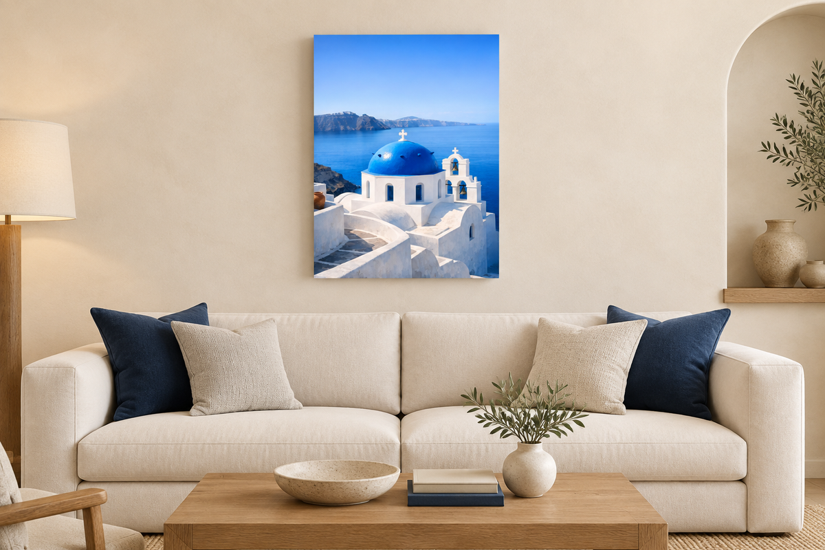 Portrait Santorini blue-dome canvas above a cream sofa with navy cushions in a warm ivory living room - Portugal Canvas Co