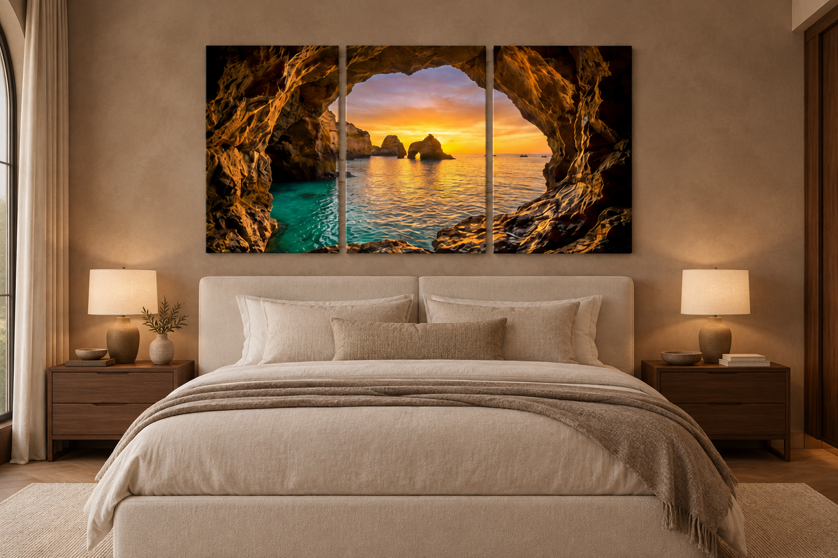Algarve cave sunset three-panel canvas displayed above an ivory bed in a taupe bedroom - Portugal Canvas Co