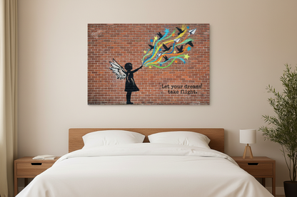 Let Your Dreams Take Flight Banksy-style graffiti canvas wall art with winged girl silhouette releasing colourful birds and paper planes displayed above a bed in a bright modern bedroom - Portugal Canvas Co
